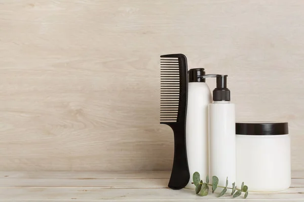 Professional hair care products with comb on table
