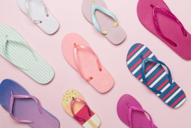 Renk arkaplanı ve üst görünümde birçok parlak parmak arası terlik