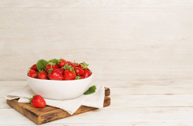 Tahta masada kasede taze çilekler.