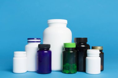 Renk arkaplanındaki vitaminler için plastik şişeler