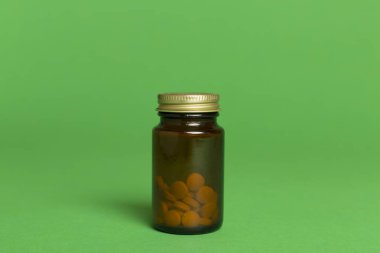 Renk arkaplanındaki vitaminler için plastik şişe