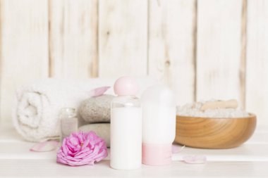 Ahşap masanın üzerinde pembe güller olan spa kompozisyonu