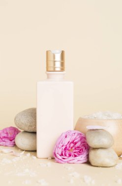 Ahşap masanın üzerinde pembe güller olan spa kompozisyonu