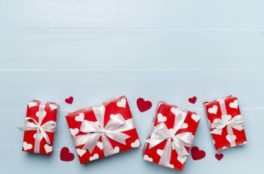 Gift boxes with hearts on wooden background, top view