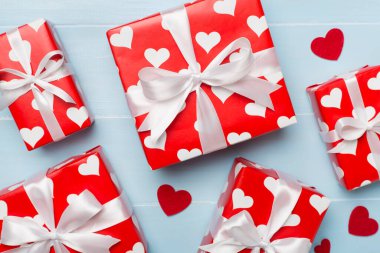 Gift boxes with hearts on wooden background, top view