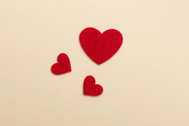 Felt hearts on color background, top view