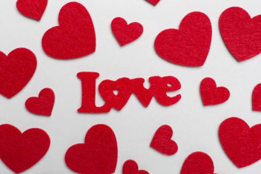 Felt word love with hearts on color background, top view