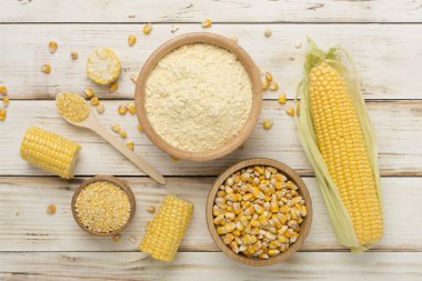 Tahta arka planda taze mısır koçanları olan mısır ürünleri, üst görünüm