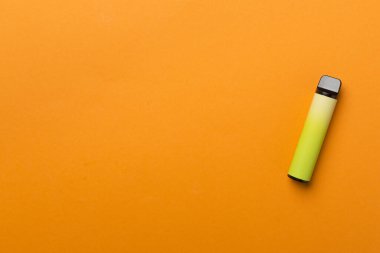 Disposable electronic cigarette on color background, top view