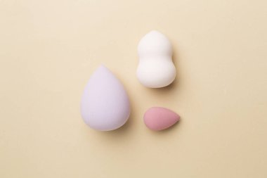 Beauty blenders on color background, top view