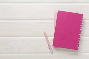 Ahşap zemin üzerinde kalem olan defterler, üst görünüm