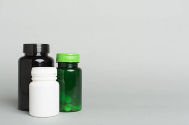 Renk arkaplanındaki vitaminler için plastik şişeler