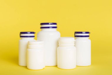 Renk arkaplanındaki vitaminler için plastik şişeler