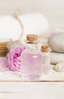 Ahşap masanın üzerinde pembe güller olan spa kompozisyonu