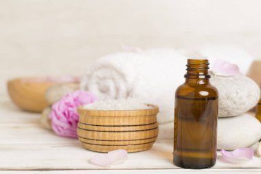 Ahşap masanın üzerinde pembe güller olan spa kompozisyonu