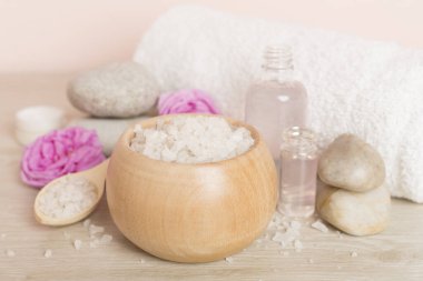 Ahşap masanın üzerinde pembe güller olan spa kompozisyonu