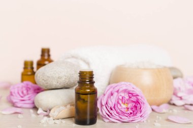 Ahşap masanın üzerinde pembe güller olan spa kompozisyonu