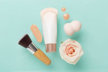 Renk arkaplanında makyaj temeli olan kompozisyon, üst görünüm