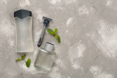 Erkekler kozmetik şişeleri, arka planda nane yaprakları, üst manzara.