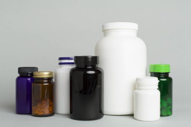 Renk arkaplanındaki vitaminler için plastik şişeler