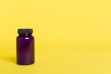 Renk arkaplanındaki vitaminler için plastik şişe