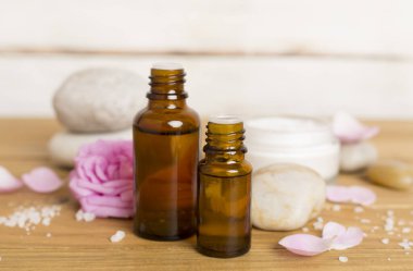 Ahşap masanın üzerinde pembe güller olan spa kompozisyonu