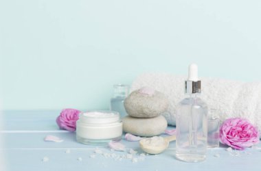 Ahşap masanın üzerinde pembe güller olan spa kompozisyonu