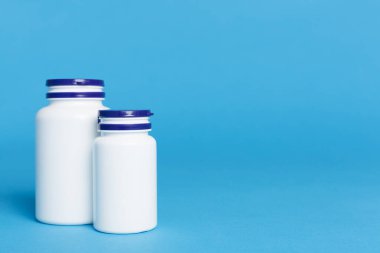 Renk arkaplanındaki vitaminler için plastik şişeler