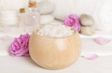 Ahşap masanın üzerinde pembe güller olan spa kompozisyonu