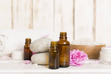 Ahşap masanın üzerinde pembe güller olan spa kompozisyonu