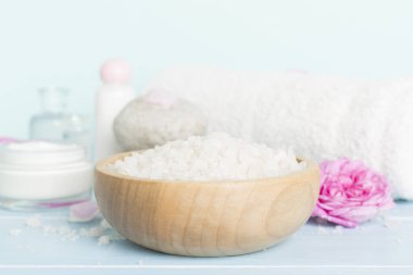 Ahşap masanın üzerinde pembe güller olan spa kompozisyonu