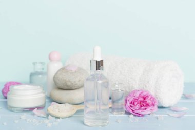 Ahşap masanın üzerinde pembe güller olan spa kompozisyonu
