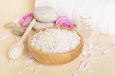 Ahşap masanın üzerinde pembe güller olan spa kompozisyonu