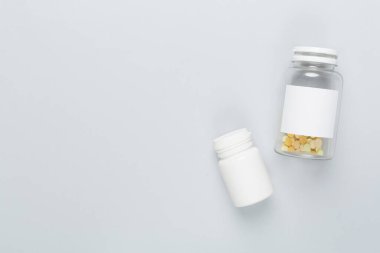 Renkli arka planda vitaminleri olan plastik şişeler, üst görünüm