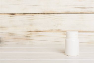 Tahta masadaki vitaminler için plastik şişe.