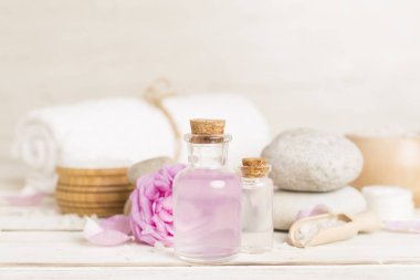 Ahşap masanın üzerinde pembe güller olan spa kompozisyonu