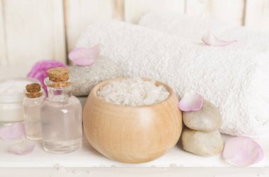 Ahşap masanın üzerinde pembe güller olan spa kompozisyonu