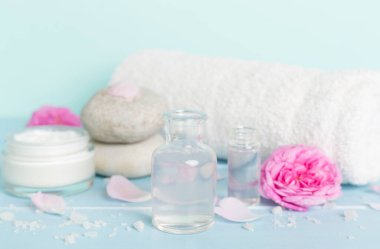 Ahşap masanın üzerinde pembe güller olan spa kompozisyonu