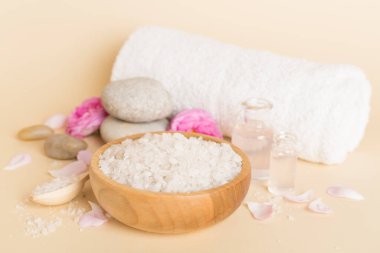 Ahşap masanın üzerinde pembe güller olan spa kompozisyonu