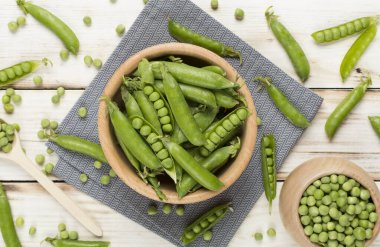 Ahşap zemin üzerinde taze bezelye ile kompozisyon, üst görünüm