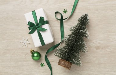 Minyatür Noel ağacı, hediye kutusu ve ahşap arka planda dekor.