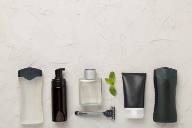 Erkekler kozmetik şişeleri, arka planda nane yaprakları, üst manzara.