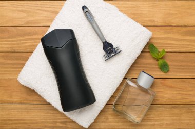 Ahşap arka planda nane yapraklı erkekler kozmetik şişeleri, üst manzara.