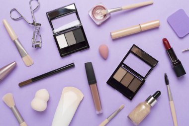 Makyaj ürünleri ve çiçeklerle renklendirilmiş araçlarla düz yatıyordu