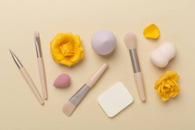 Renk arkaplanında makyaj fırçaları ve süngerler, üst görünüm