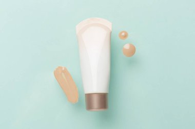 Renk arkaplanında makyaj temeli olan kompozisyon, üst görünüm