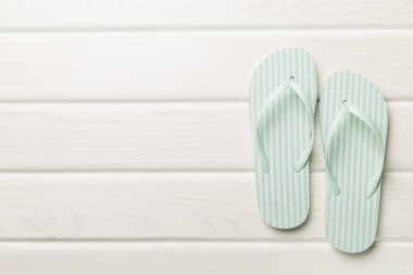 Ahşap arka planda çizgili parmak arası terlikler, üst görünüm