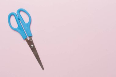 Renkli arka plan üzerinde mavi makas, üst görünüm