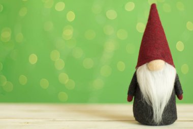 Bulanık ışıklara karşı masada Noel cücesi