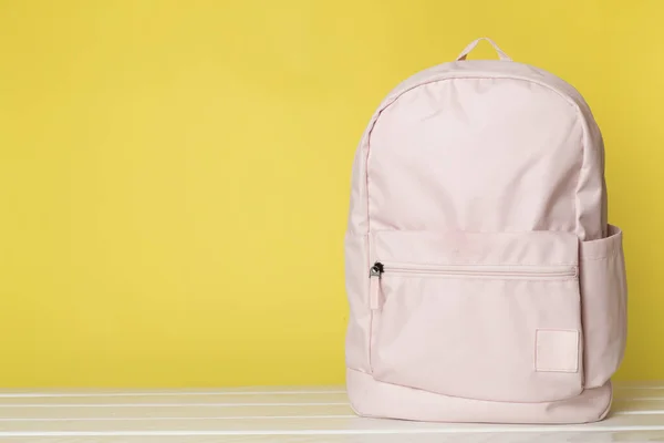 Pink school backpack on wooden table